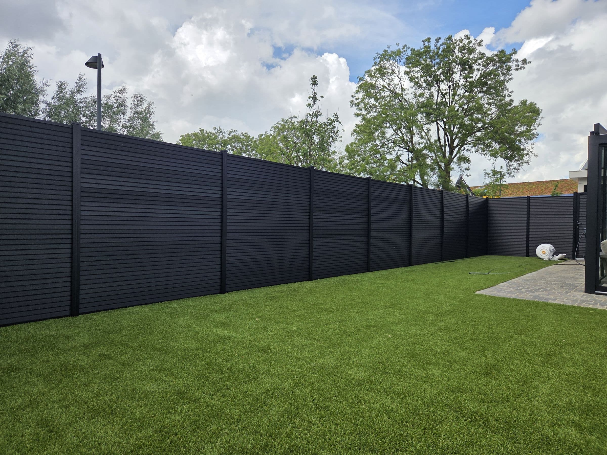 Composiet antraciet: Antraciet schutting rond een tuin met kunstgras
