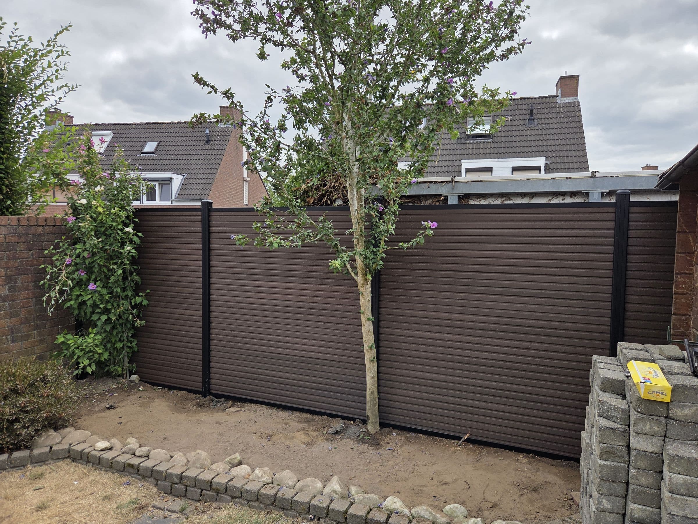 Composiet houtlook: Bruine composiet schutting om een boom heen