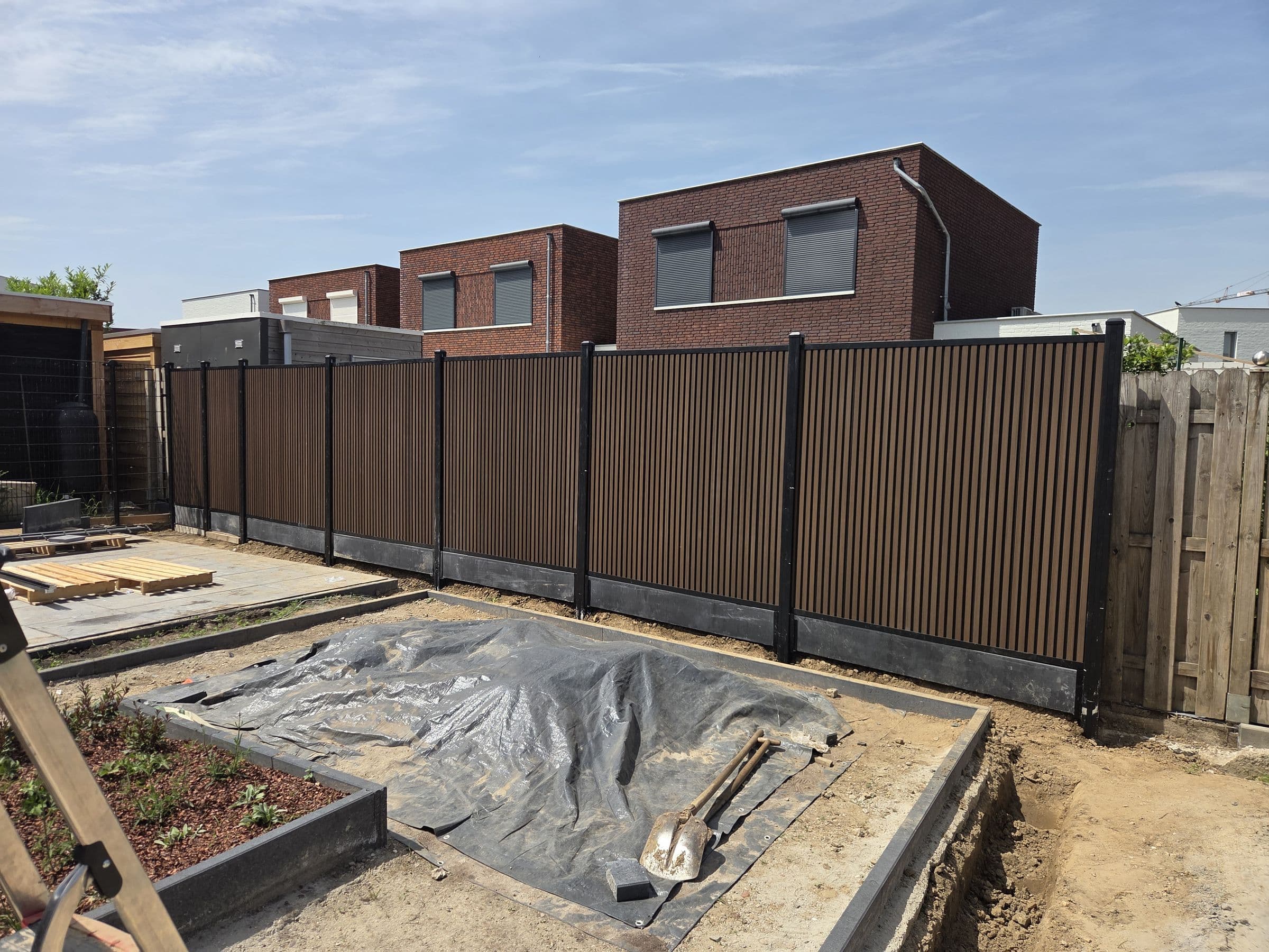 Composiet houtlook: Bruine composiet schutting bij een nieuwbouwwoning