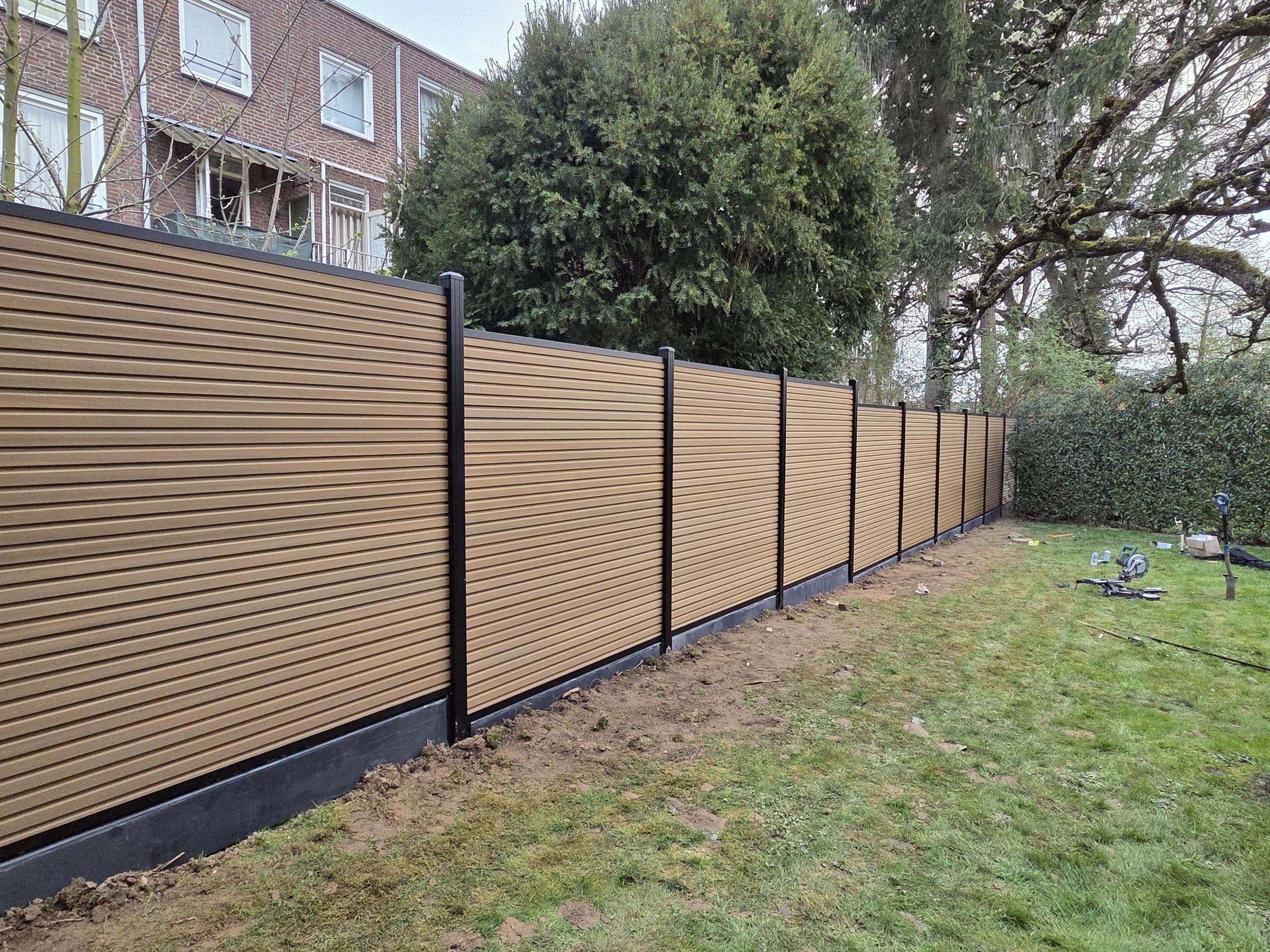 Composiet houtlook: Composiet schutting in houtlook achter een rijwoning