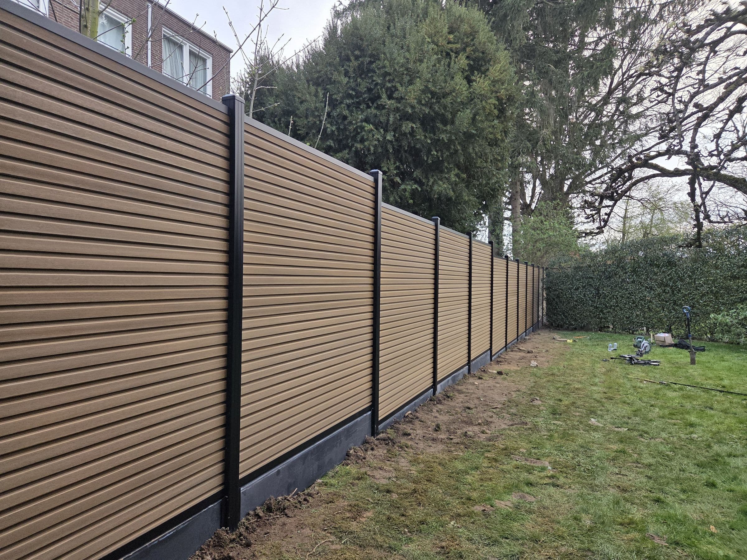 Composiet houtlook: Houtlook schutting over de volle lengte van de tuin