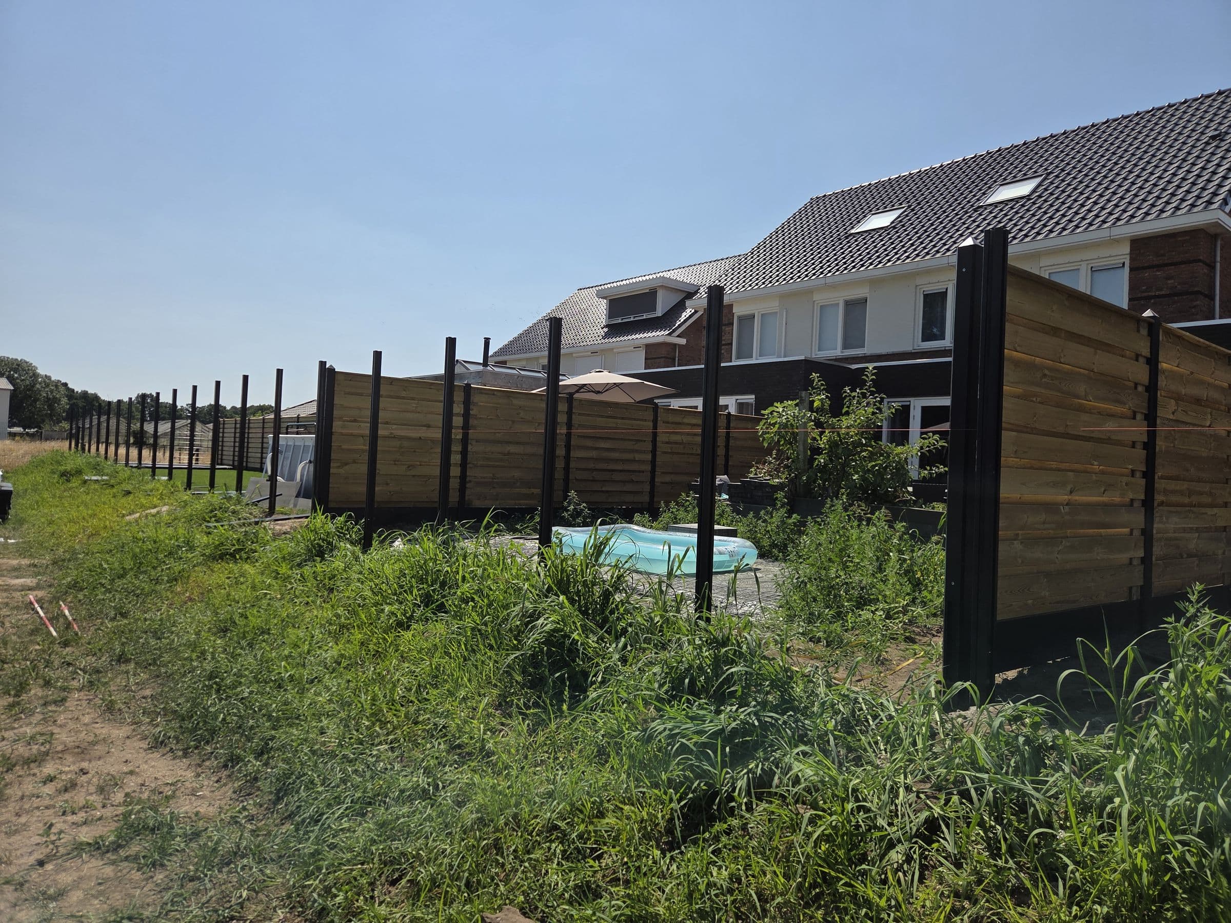 Composiet houtlook: Houtlook schutting op de grens met een weiland