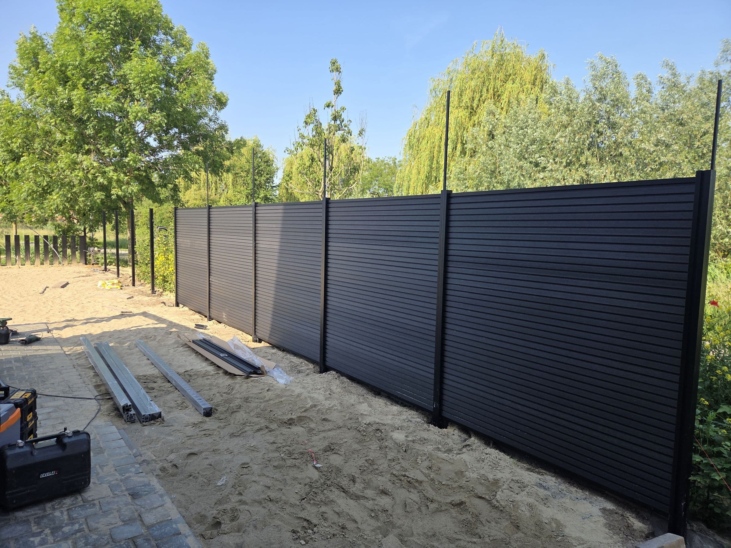 In uitvoering: Antraciet planken gaan tussen de palen